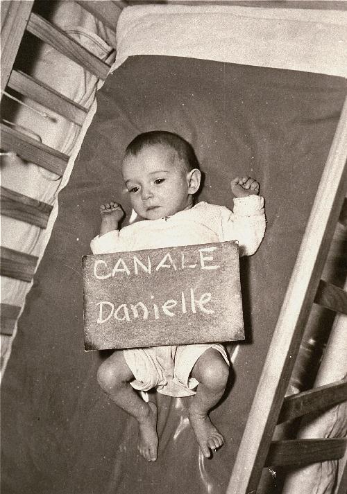 Een kind met naambordje, bedoeld om haar familie te helpen haar te vinden. De foto werd in kranten gepubliceerd.